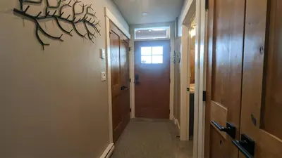 a hallway with a wooden door and a hallway at Echo Landing #13 condo in Sun Peaks