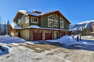 a house with a garage in the snow at Altitude #36 condo in Sun Peaks