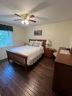 a bedroom with a bed and a ceiling fan at Bluejay Suites B&B in Whitehorse