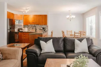 a living room with a couch and a kitchen at Trailblazers Retreat 3 Bed with Family Games Room in Big White