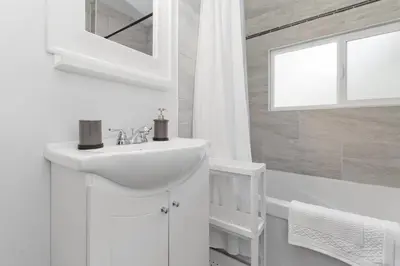 a white bathroom with a sink and a mirror at Lake Time Harrison in Harrison Hot Springs
