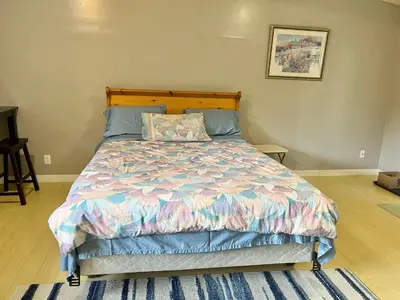 a bed with a colorful comforter in a bedroom at Whole Suite to Yourself at Coquitlam Centre! in Port Coquitlam