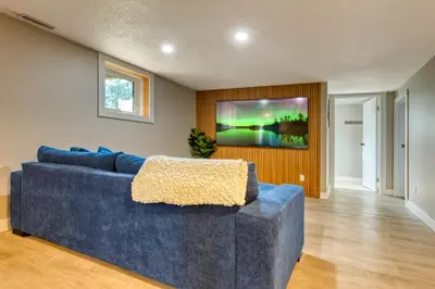a blue couch in a living room with a painting on the wall at Backyard Oasis Hot Tub, BBQ, Outdoor Bar in Invermere
