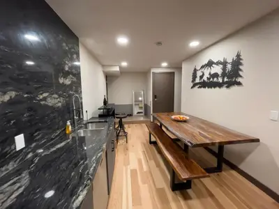 a room with a wooden table and a counter at Romantic Luxury Retreat with Private Sauna & Spa, Pet Friendly, Elkside Hideout B&B in Canmore
