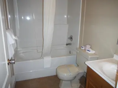 a bathroom with a toilet and a tub and a sink at Tumbler Ridge Inn in Tumbler Ridge