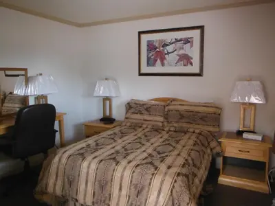 a hotel room with a bed and two lamps at Tumbler Ridge Inn in Tumbler Ridge
