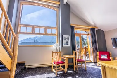 a room with chairs and a large window at Brewster Mountain Lodge in Banff