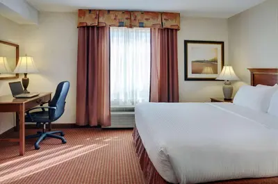 a hotel room with a bed and a desk and a window at Coast Grimshaw Hotel & Suites in Grimshaw