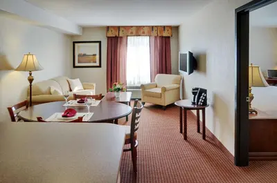 a hotel room with a table and a living room at Coast Grimshaw Hotel & Suites in Grimshaw