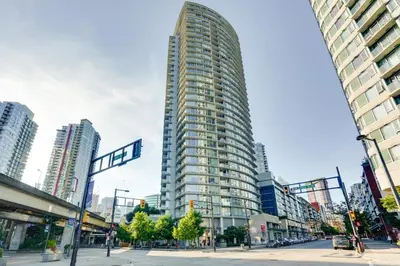 a tall building in the middle of a city at Heart of Downtown 1 bd Entire Condo - Pool, Gym, Parking, Office, AC in Vancouver