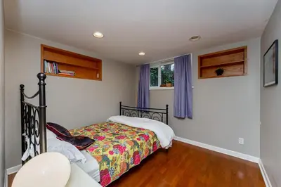 a bedroom with a bed and a window at Garden suite on Trinity St in Vancouver