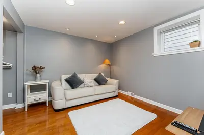 a living room with a white couch and a window at Garden suite on Trinity St in Vancouver