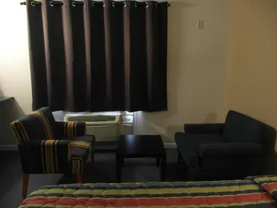 a living room with a couch and a chair and a window at West View Motel in Hanna