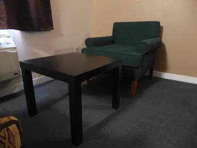 a living room with a chair and a table at West View Motel in Hanna