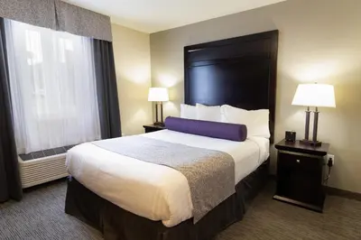 a hotel room with a large bed and two lamps at The Kanata by BCMInns Blairmore in Blairmore