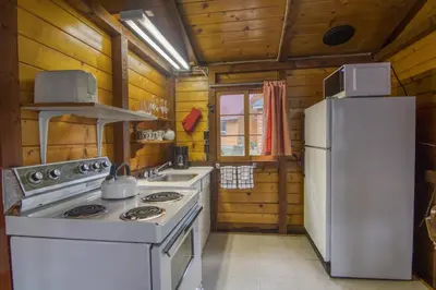 a kitchen with a white stove and a refrigerator at Timbers Resort in Fairmont Hot Springs