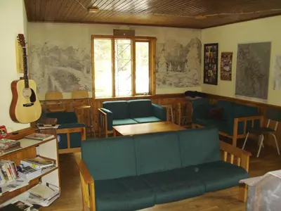 a living room with a couch and a guitar at HI Mosquito Creek - Wilderness Hostel in Lake Louise