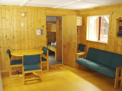 a living room with a table and a couch at HI Mosquito Creek - Wilderness Hostel in Lake Louise