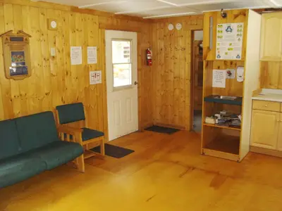 a room with wooden walls and a couch and a door at HI Mosquito Creek - Wilderness Hostel in Lake Louise