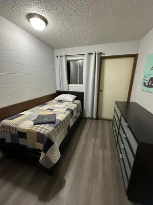 a bedroom with a bed and a dresser in it at Cozy Beach 2 bedroom apartment in Invermere