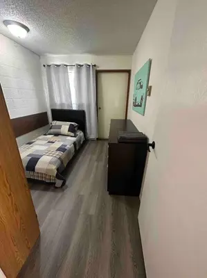a bedroom with a bed and a desk in it at Cozy Beach 2 bedroom apartment in Invermere