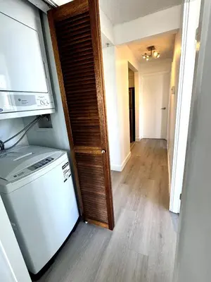 a kitchen with a washer and dryer and a hallway at Stunning ocean (sound of waves) in Vancouver