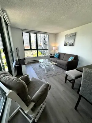 a living room with a couch and a chair at Stunning ocean (sound of waves) in Vancouver