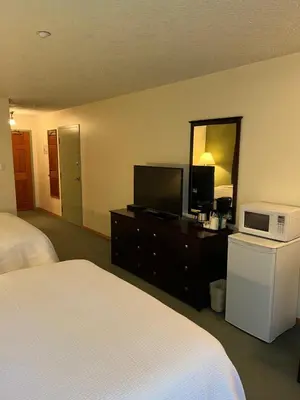 a hotel room with two beds and a television at The Grand Hotel Nanaimo in Nanaimo