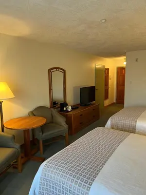 a hotel room with a bed and a desk and a tv at The Grand Hotel Nanaimo in Nanaimo
