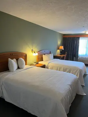 a hotel room with two beds and a window at The Grand Hotel Nanaimo in Nanaimo