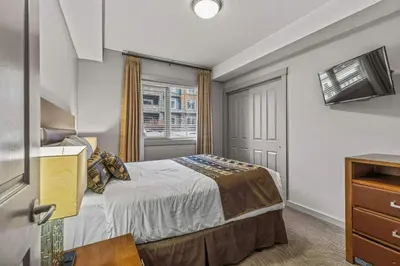 a small bedroom with a bed and a window at Rocky Mountain Getaway with Outdoor Heated Pool, 3 Hot Tubs, Gym, BBQ, Garage & 24 hour Reception near Banff in Canmore