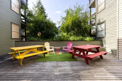a patio with two picnic tables and colorful chairs at Powderview 12 by Whistler Premier in Whistler