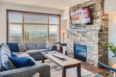 a living room with a couch and a fireplace at The Crescent 201 by Okanagan Premier in Big White