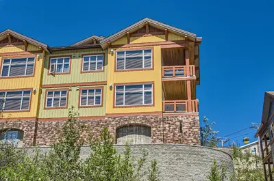 a large yellow house on top of a building at The Crescent 201 by Okanagan Premier in Big White