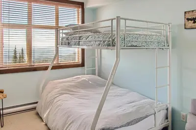 a white bunk bed in a room with a window at The Crescent 201 by Okanagan Premier in Big White