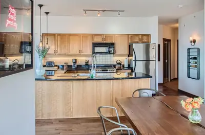 a kitchen with wooden cabinets and a table and a refrigerator at The Crescent 201 by Okanagan Premier in Big White