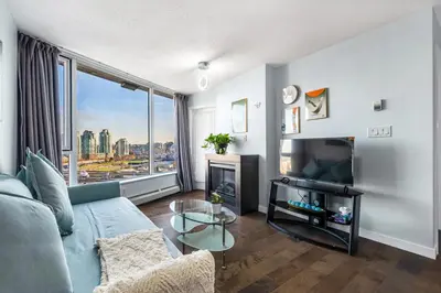 a living room with a couch and a large window at Downtown 1 Bedroom Water View Condo in Vancouver