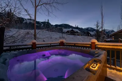 a jacuzzi tub with purple lighting in the snow at Lush Mountain Accommodations in Golden