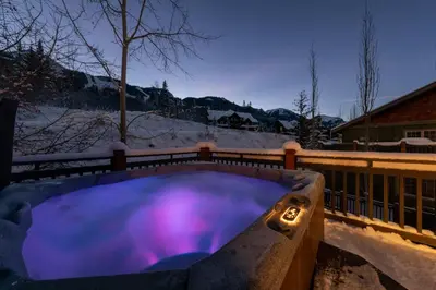 a hot tub with purple lights in the snow at Lush Mountain Accommodations in Golden