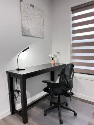 a black desk with a chair and a lamp at Private Entire Townhouse Retreat Close to Lake in Calgary