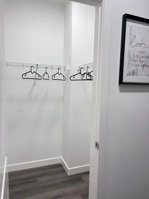 a room with white walls and a door with black hooks at Private Entire Townhouse Retreat Close to Lake in Calgary