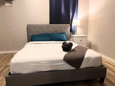 a bedroom with a large bed with blue pillows at Flowealth Suites - Private Rooms Near West Edmonton Mall in Edmonton