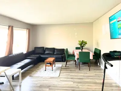 a living room with a couch and a table at Flowealth Suites - Private Rooms Near West Edmonton Mall in Edmonton