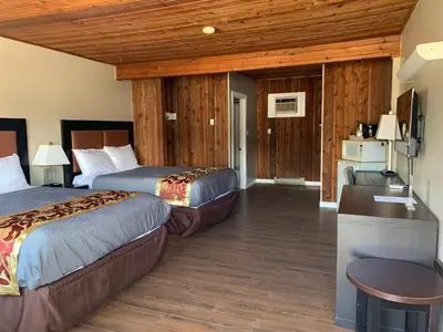 a hotel room with two beds and a desk at Rondo Motel in Golden