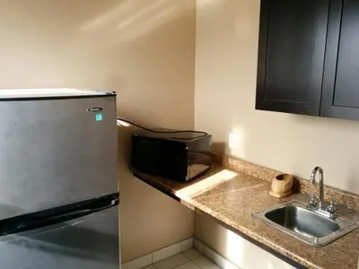 a kitchen with a stainless steel refrigerator and a sink at Bonnyville Hotel in Bonnyville
