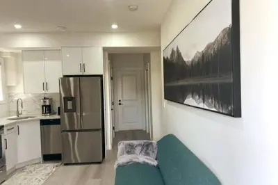 a kitchen with a green couch and a refrigerator at Award winning boho paradise sunlit modern suite in Calgary