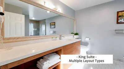 a bathroom with a sink and a large mirror at Gibsons Garden Hotel in Gibsons