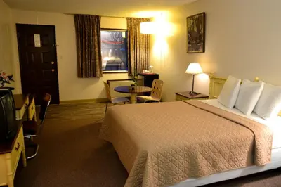 a hotel room with a bed and a television at Hoo-Doo Motel in Drumheller