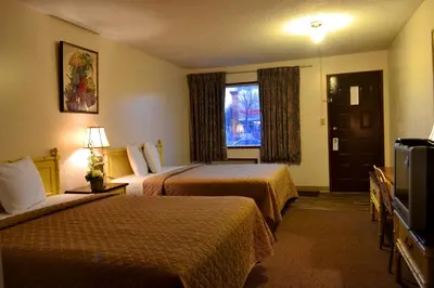 a hotel room with two beds and a window at Hoo-Doo Motel in Drumheller