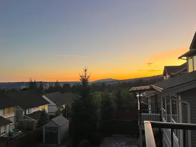 a view of the sunset from the balcony of a house at Derbyshire House in Coquitlam